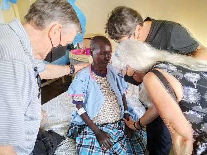 LOMAMO team praying with Kezia in the women’s medical ward